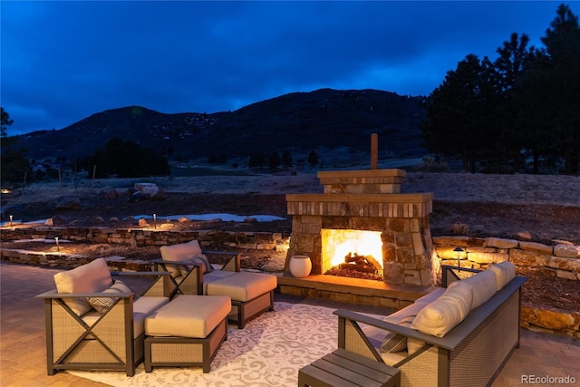 8033 Galileo Way, Littleton, CO 80125 - view of patio / terrace with a mountain view and an outdoor stone fireplace