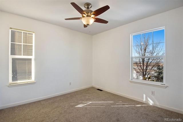 empty room featuring carpet, a healthy amount of sunlight, and ceiling fan