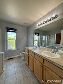 bathroom with tile patterned flooring, double vanity, and toilet