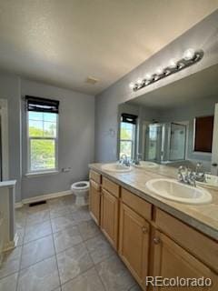 bathroom with tile patterned flooring, double vanity, and toilet