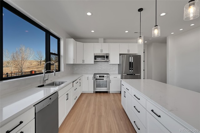 804 Spyglass Cir, Louisville, CO 80027 - kitchen featuring decorative backsplash, recessed lighting, light wood-type flooring, a sink, and appliances with stainless steel finishes