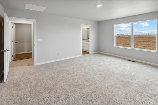 unfurnished bedroom with ensuite bath and light carpet