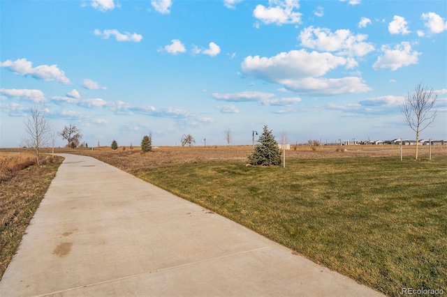 view of property's community featuring a yard and a rural view