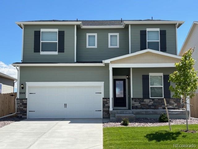 2244 Alyssa St, Fort Lupton, CO 80621 - craftsman house featuring stone siding, a porch, driveway, and a garage