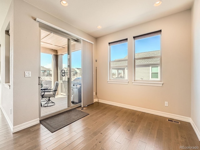 doorway to outside with recessed lighting, visible vents, baseboards, and wood finished floors