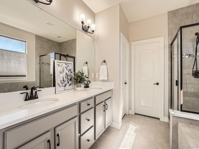 bathroom with tile patterned floors, a stall shower, and a sink