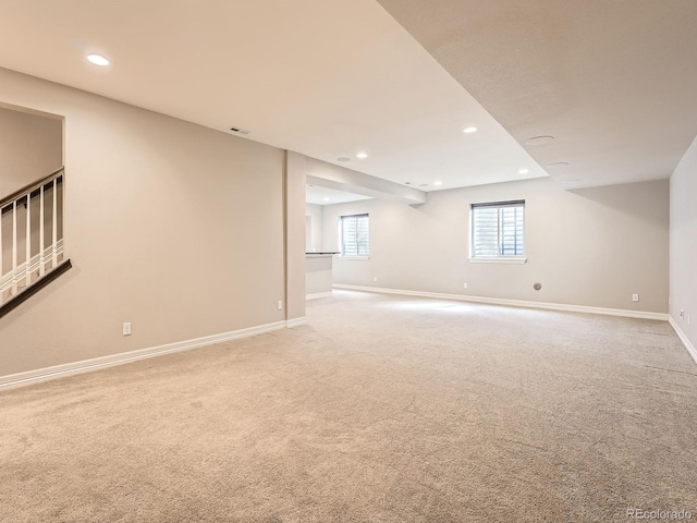 unfurnished room with recessed lighting, baseboards, and light carpet