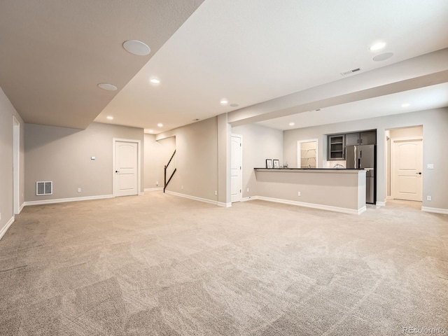 unfurnished living room featuring recessed lighting, visible vents, light carpet, and baseboards