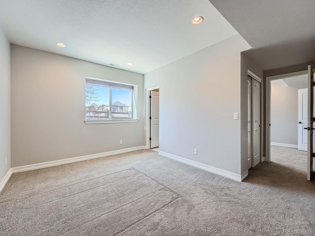 empty room featuring recessed lighting, baseboards, carpet, and a textured ceiling