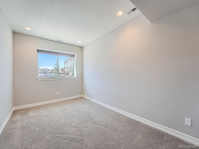 carpeted spare room featuring visible vents, recessed lighting, and baseboards