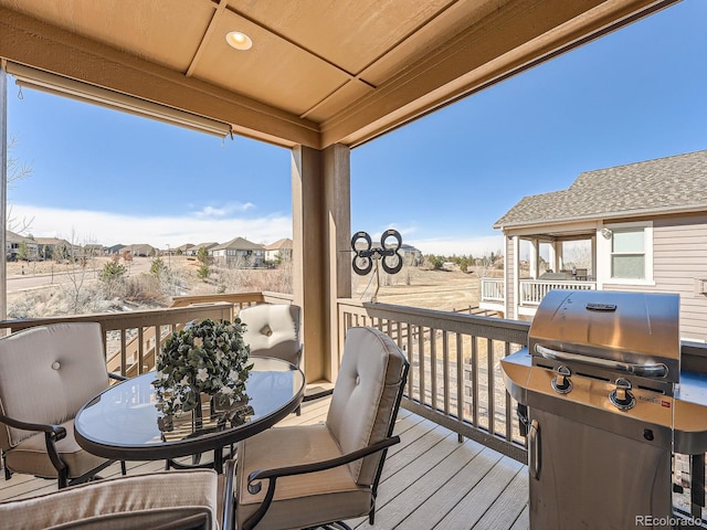 wooden terrace with area for grilling and outdoor dining area