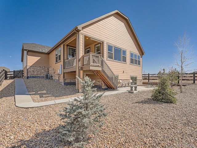 back of house featuring stairs, central AC unit, and a fenced backyard