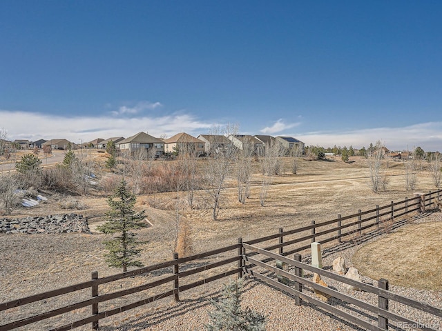 view of yard featuring a residential view, a rural view, and fence