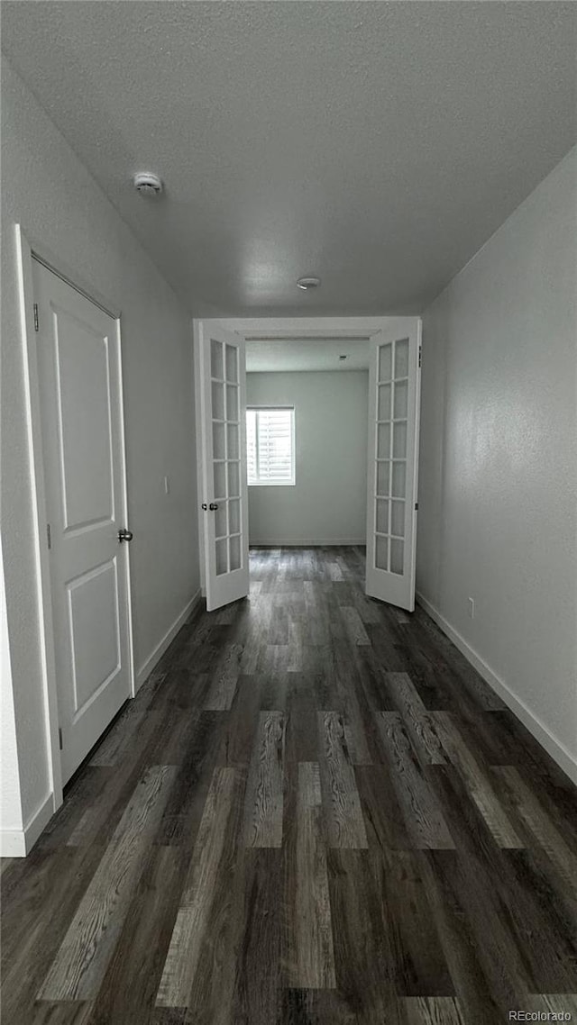 unfurnished room with dark hardwood / wood-style flooring, a textured ceiling, and french doors