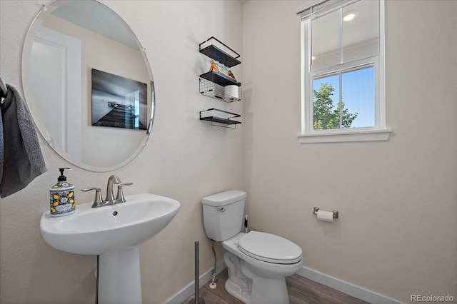 bathroom with wood-type flooring, toilet, and sink