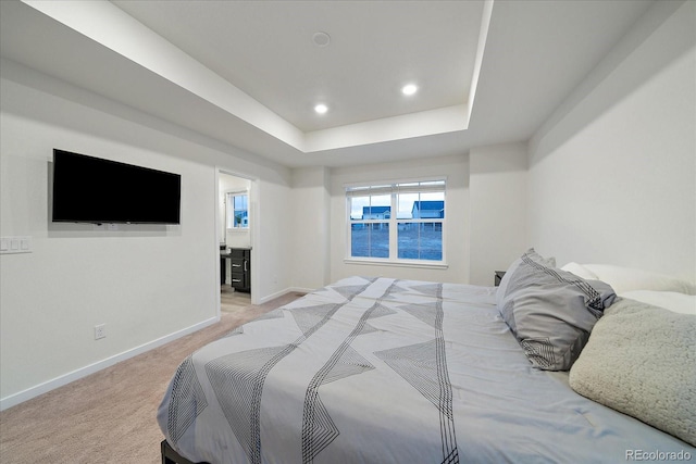 bedroom featuring light carpet and a tray ceiling