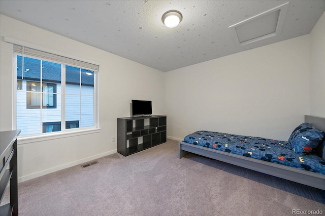 bedroom with a textured ceiling and light carpet