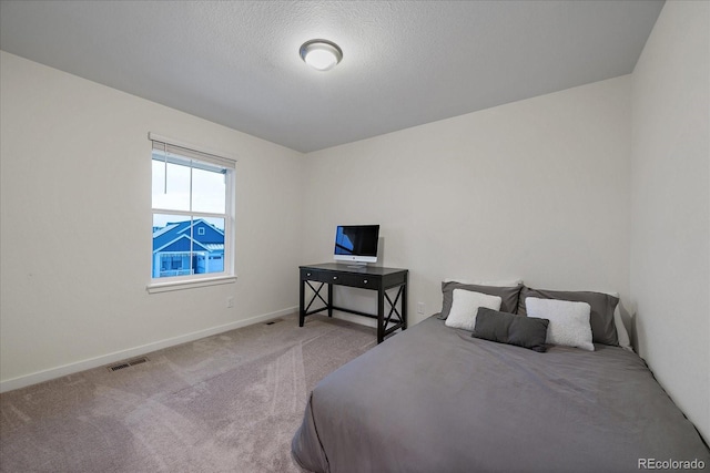 bedroom with carpet flooring and a textured ceiling