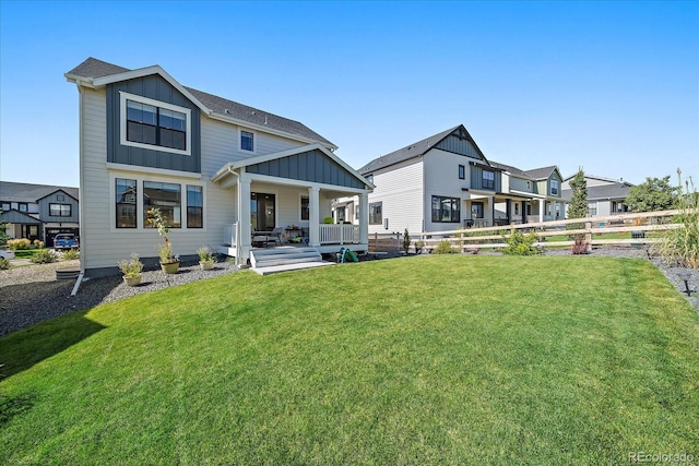 rear view of property with a yard and covered porch