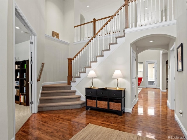 entryway with dark wood-type flooring and a high ceiling