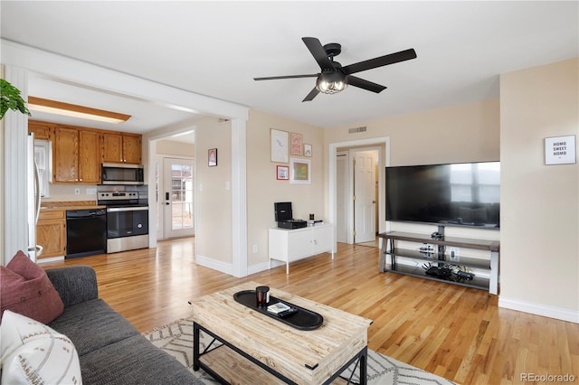 living room featuring light wood-type flooring and ceiling fan