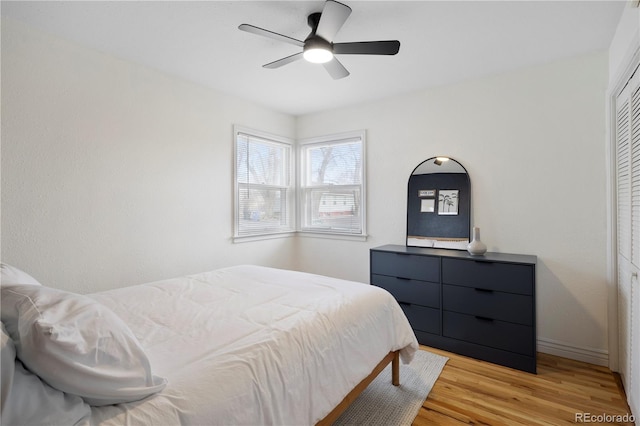 bedroom featuring ceiling fan, a closet, and light wood-type flooring