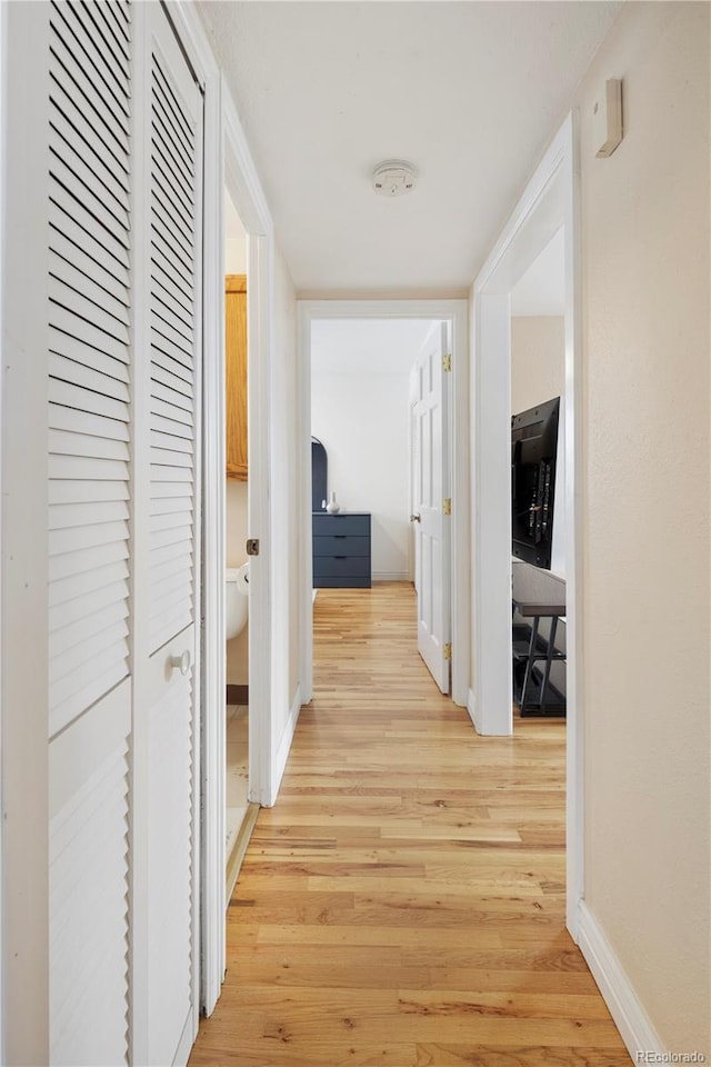 corridor with light hardwood / wood-style floors