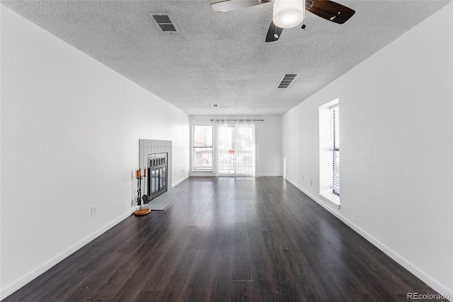 unfurnished living room featuring ceiling fan, dark hardwood / wood-style flooring, and a textured ceiling