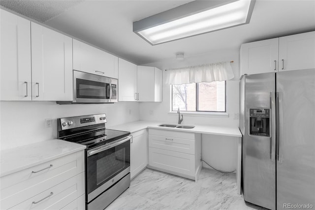 kitchen featuring light stone countertops, white cabinetry, sink, and appliances with stainless steel finishes