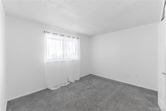 carpeted empty room with a textured ceiling