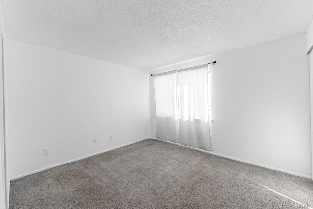 carpeted empty room with a textured ceiling