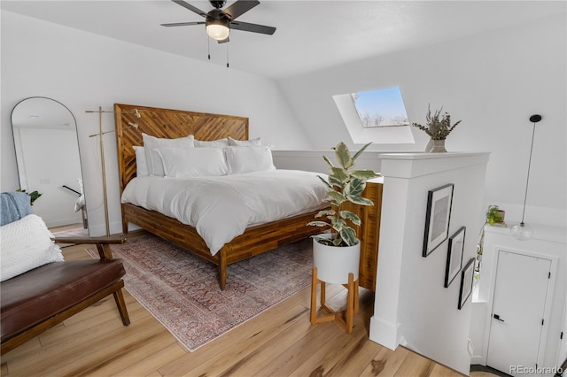 bedroom with a skylight, light wood finished floors, and a ceiling fan