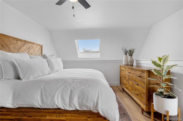 bedroom with light wood-style floors, a ceiling fan, and a skylight