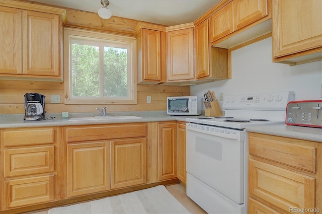 kitchen with light brown cabinetry, white appliances, light countertops, and a sink