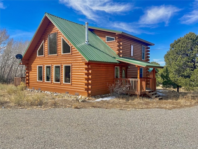 view of side of property with log siding and metal roof