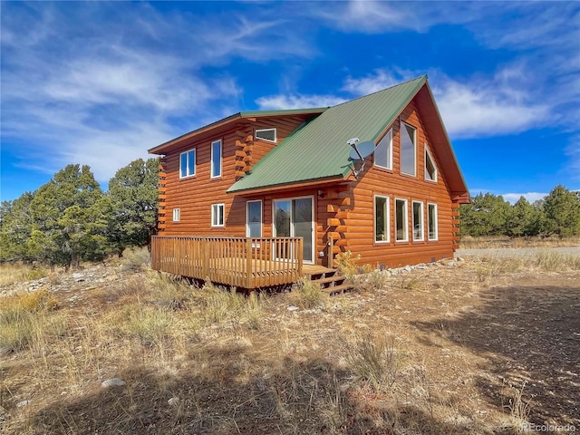 rear view of house featuring metal roof, a wooden deck, and log exterior