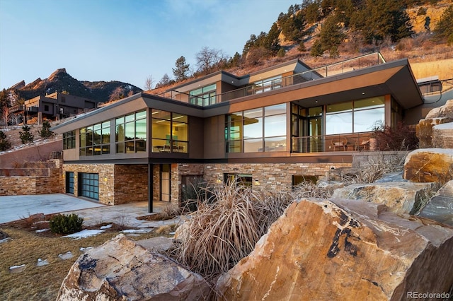 back of house with a mountain view and a garage