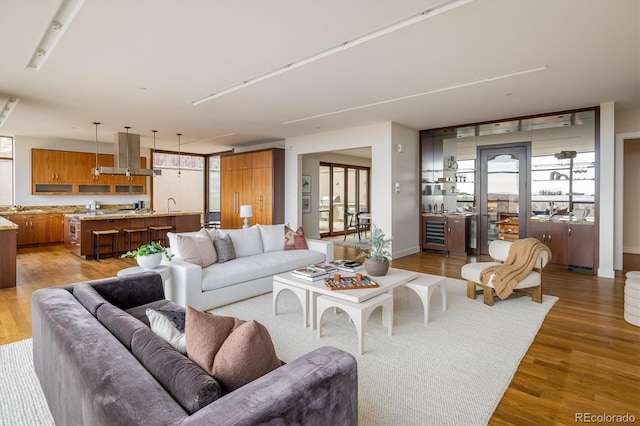 living room featuring beverage cooler, dark hardwood / wood-style floors, and sink