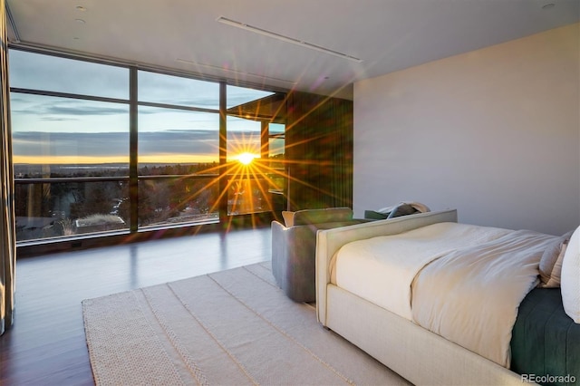 bedroom with wood-type flooring and expansive windows