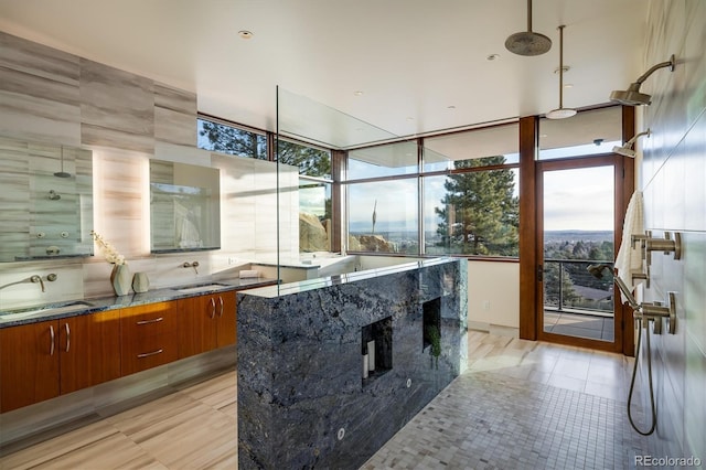 kitchen with tasteful backsplash, sink, light tile patterned floors, and dark stone counters