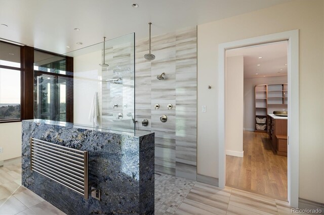 bathroom featuring tile patterned flooring and a tile shower