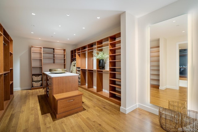 walk in closet with light hardwood / wood-style floors