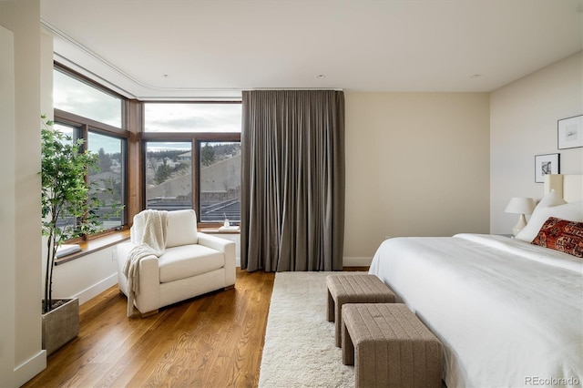 bedroom with multiple windows and hardwood / wood-style floors