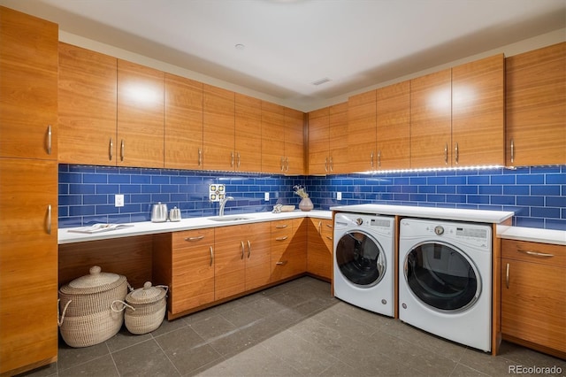 laundry room with independent washer and dryer, cabinets, and sink