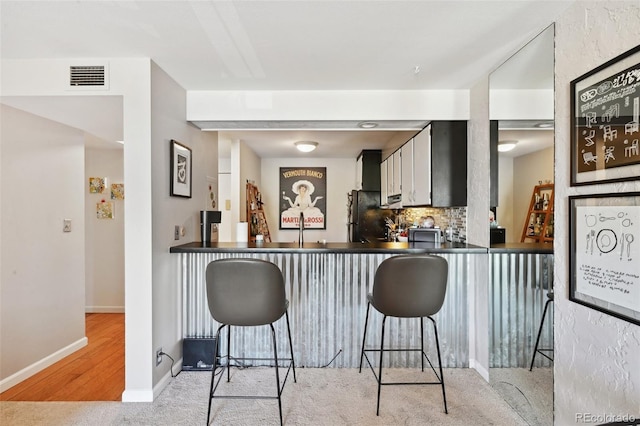 805 29th St Unit 308, Boulder, CO 80303 - kitchen featuring freestanding refrigerator, dark countertops, backsplash, a breakfast bar, and baseboards