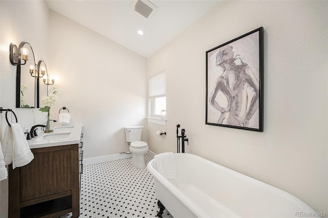 bathroom with vanity, lofted ceiling, toilet, and a washtub