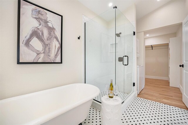 bathroom featuring independent shower and bath, hardwood / wood-style floors, and lofted ceiling