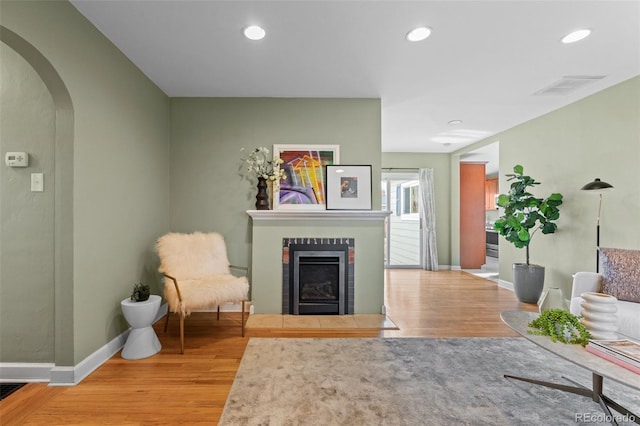 sitting room featuring wood-type flooring and a tile fireplace