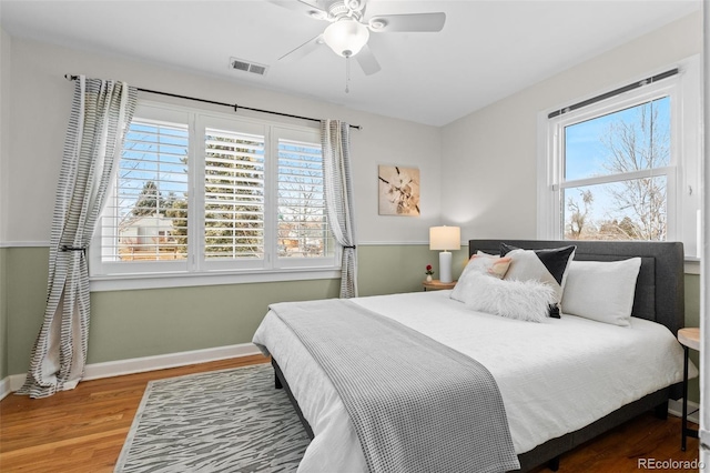 bedroom featuring multiple windows, wood-type flooring, and ceiling fan