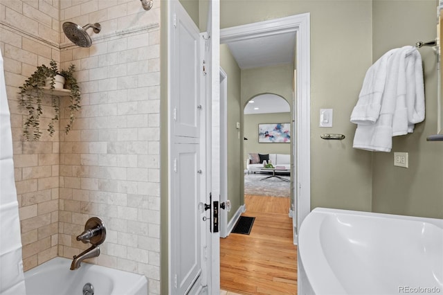 bathroom with shower / bath combination with curtain and wood-type flooring